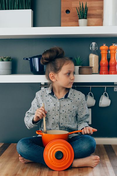 bambina con pentola in cucina 