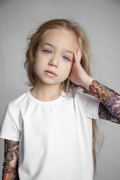 bambina con tatuaggi sul braccio