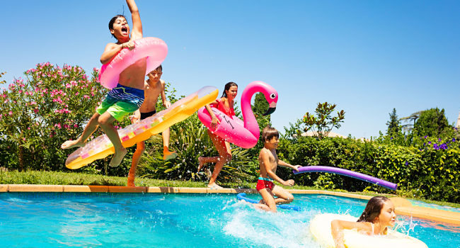 Amici felici che saltano in piscina durante un pool party