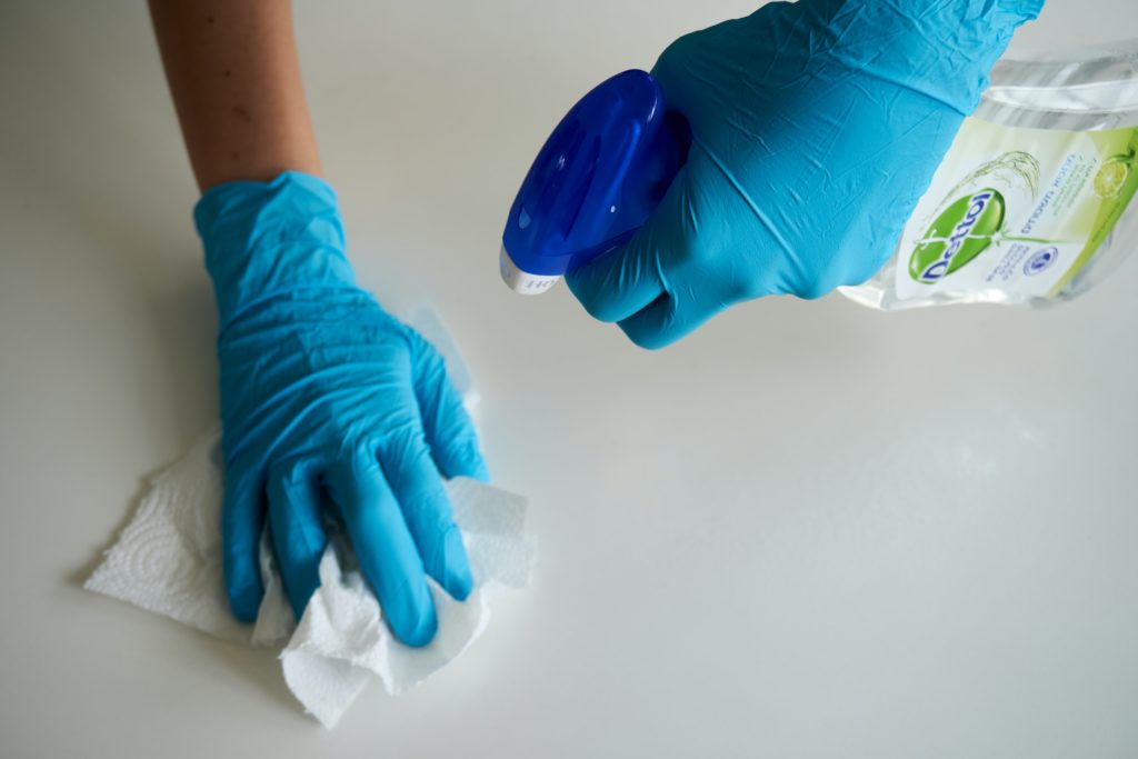 Mani che puliscono una superficie bianco-lucido