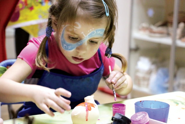 Bambina truccata che gioca con in colori