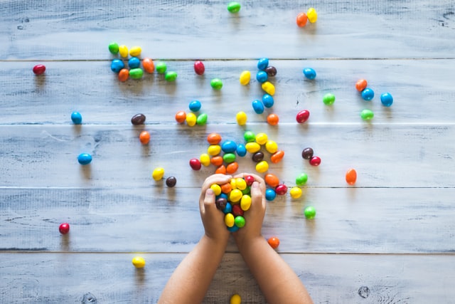 Mani di un bambino che gioca con smarties!