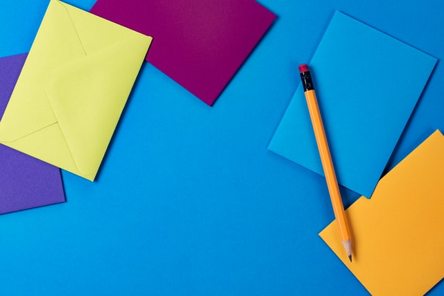 buste di carta colorate con matita su sfondo azzurro per uno dei giochi musicali per bambini
