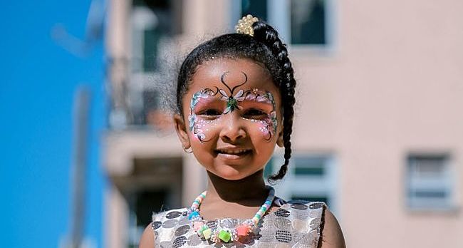 Bambina con il viso decorato con il truccabimbi farfalla