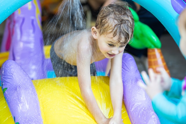 bambino pronto a scendere su uno scivolo ad acqua affittato tramite un servizio di noleggio gonfiabili