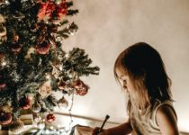 bambina scrive la letterina a babbo natale durante la festa a tema natale