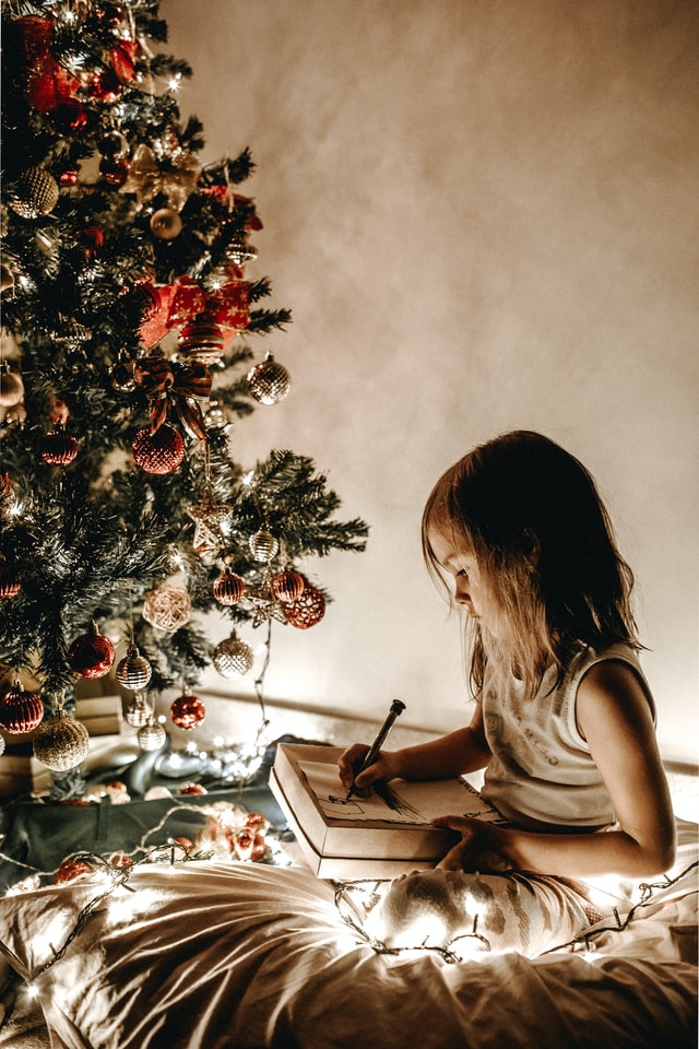 bambina scrive la letterina a babbo natale durante la festa a tema natale