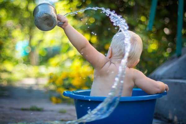 Bambino che fa il bagnetto e gioca