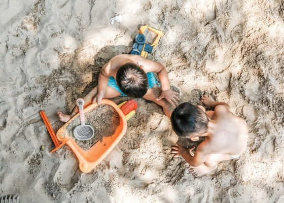 Bambini che giocano con la sabbia al mare